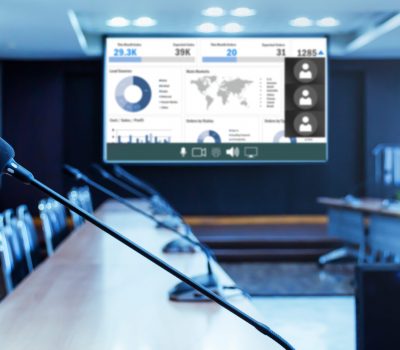 Close up microphone on table with presentation on projector screen background in meeting room